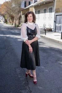 Dr. Ferguson posing on street in black pleated dress and white blouse