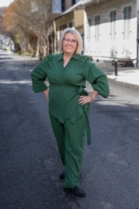 Juannette smiling in green outfit standing confidently on city street